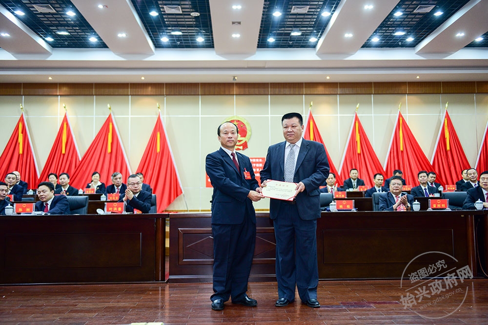 湯愛亮當(dāng)選為始興縣人民政府副縣長(zhǎng)，，圖為賴根為湯愛亮（右）頒發(fā)當(dāng)選證書