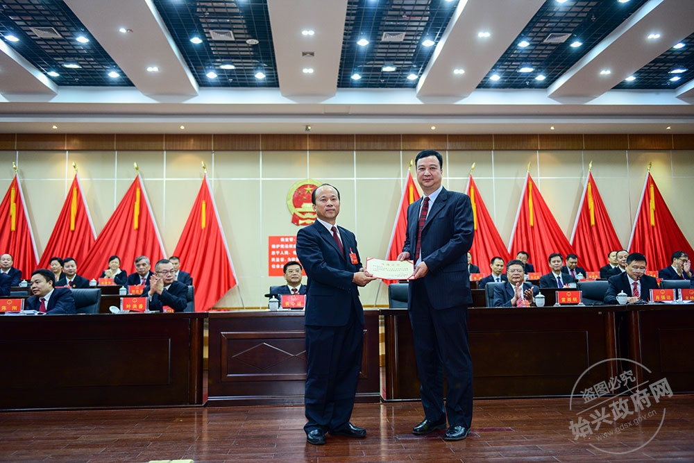 余志強(qiáng)當(dāng)選為始興縣人民政府副縣長(zhǎng)，，圖為賴根為余志強(qiáng)（右）頒發(fā)當(dāng)選證書