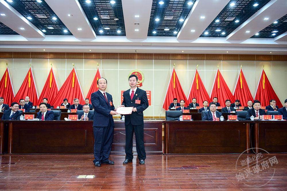 廖海岷當(dāng)選始興縣人民法院院長(zhǎng)，圖為賴根為廖海岷（右）頒發(fā)當(dāng)選證書
