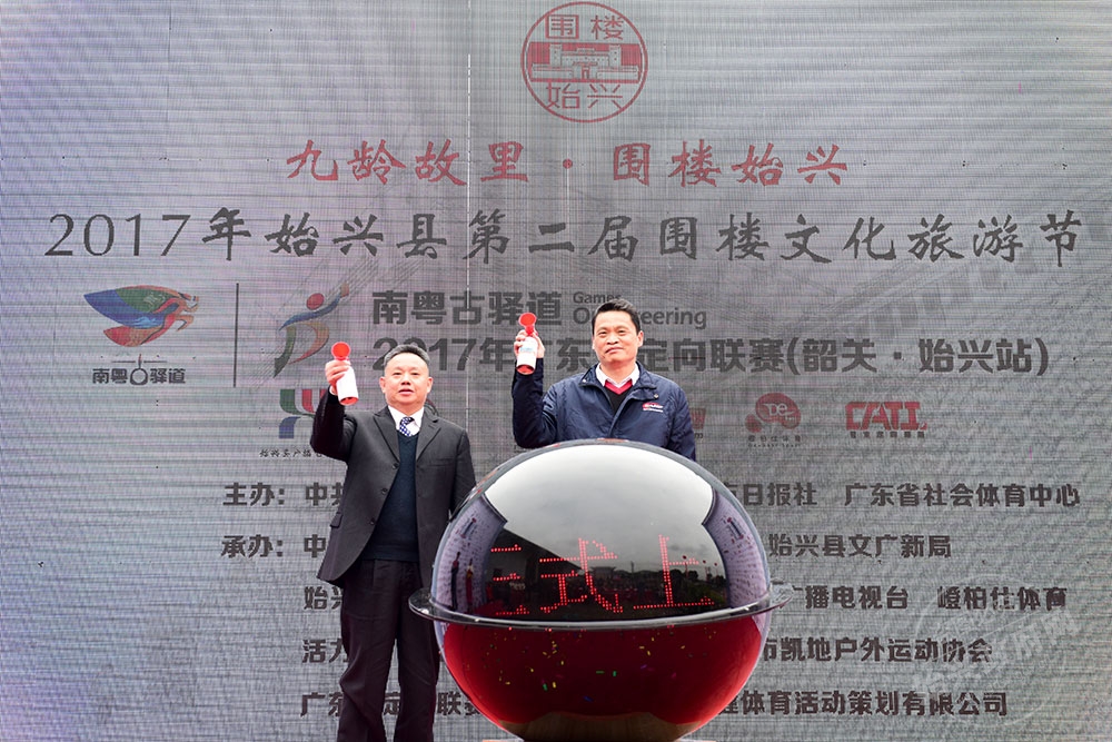 當(dāng)天上午，始興圍樓定向聯(lián)賽開賽，圖為省體育局副局長麥良和縣委書記黃建華共同鳴笛